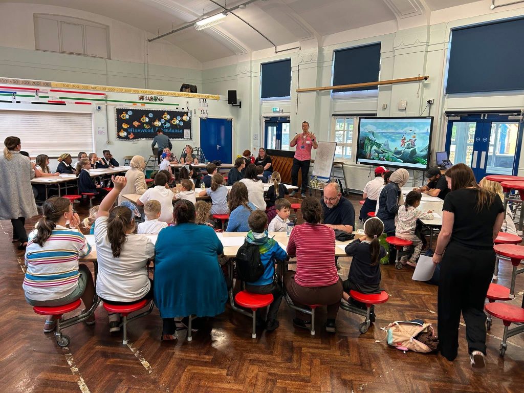 Adam Thornton presenting a workshop on illustration to a group of primary school children and their parents.